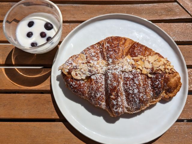 アーモンドクロワッサンをヨーグルトと食べる様子の写真